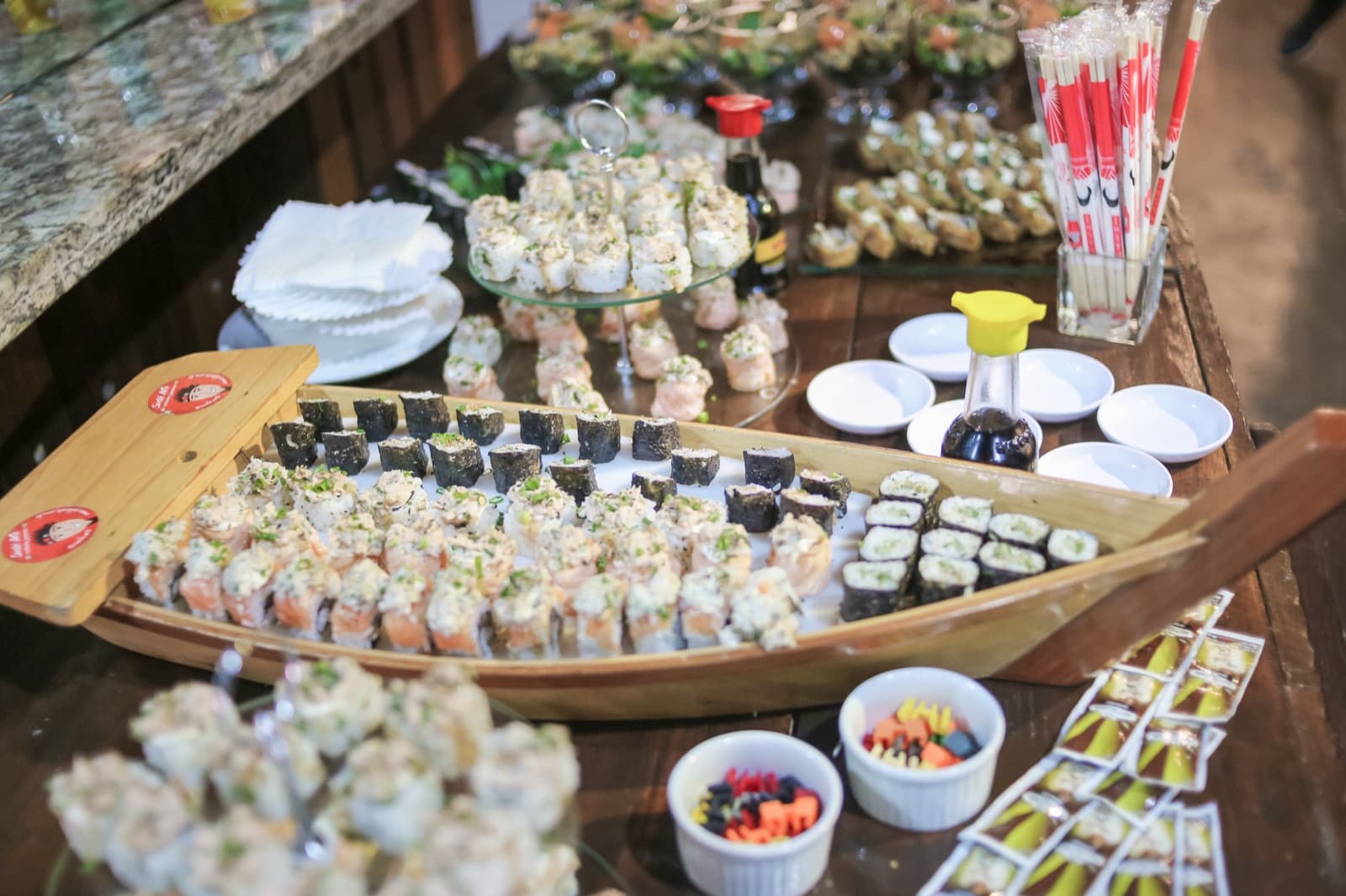 Ilha de sushi servida em barco de madeira no buffet da festa
