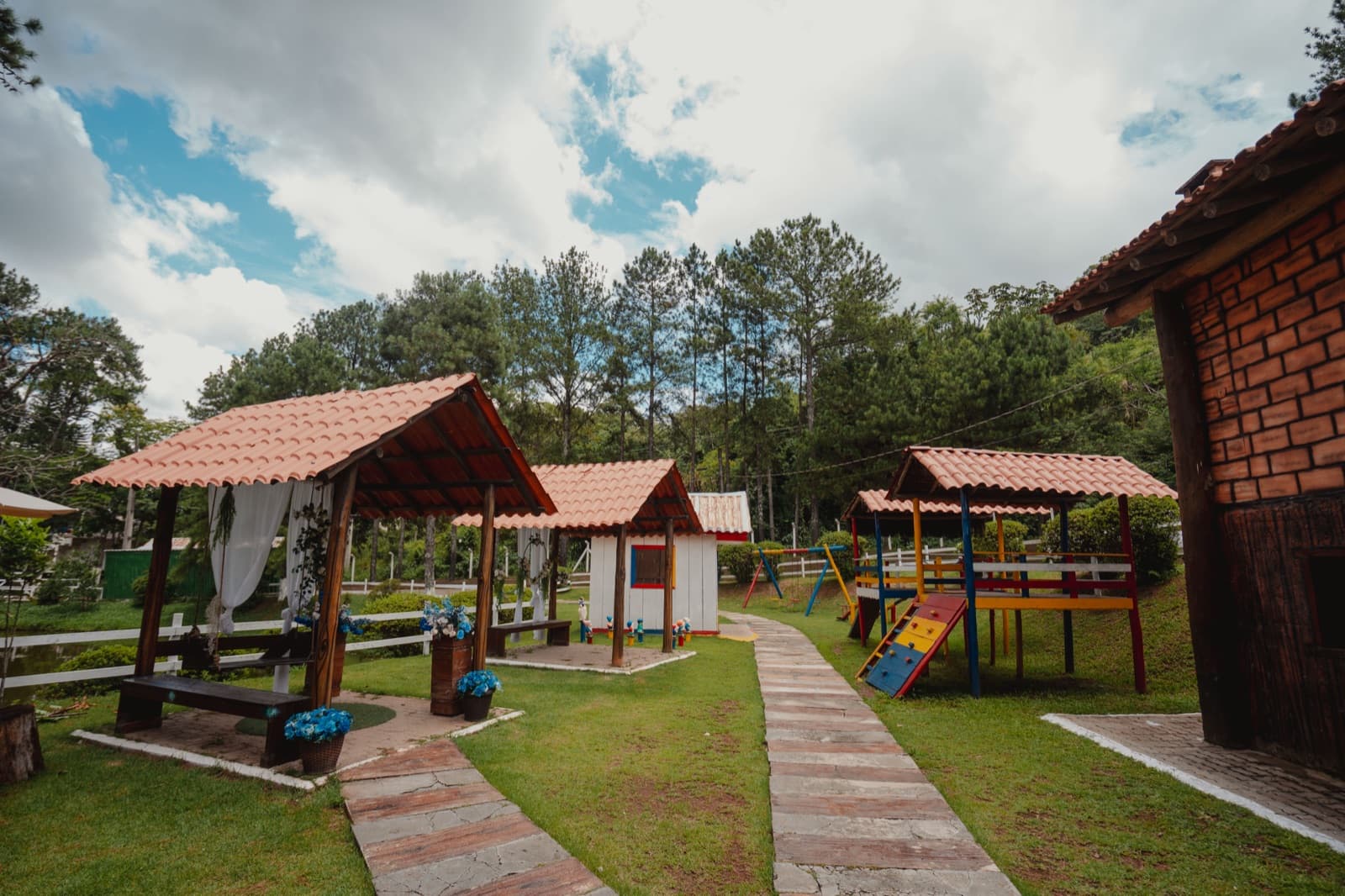 Espaço kids com casinhas e playground em meio ao jardim