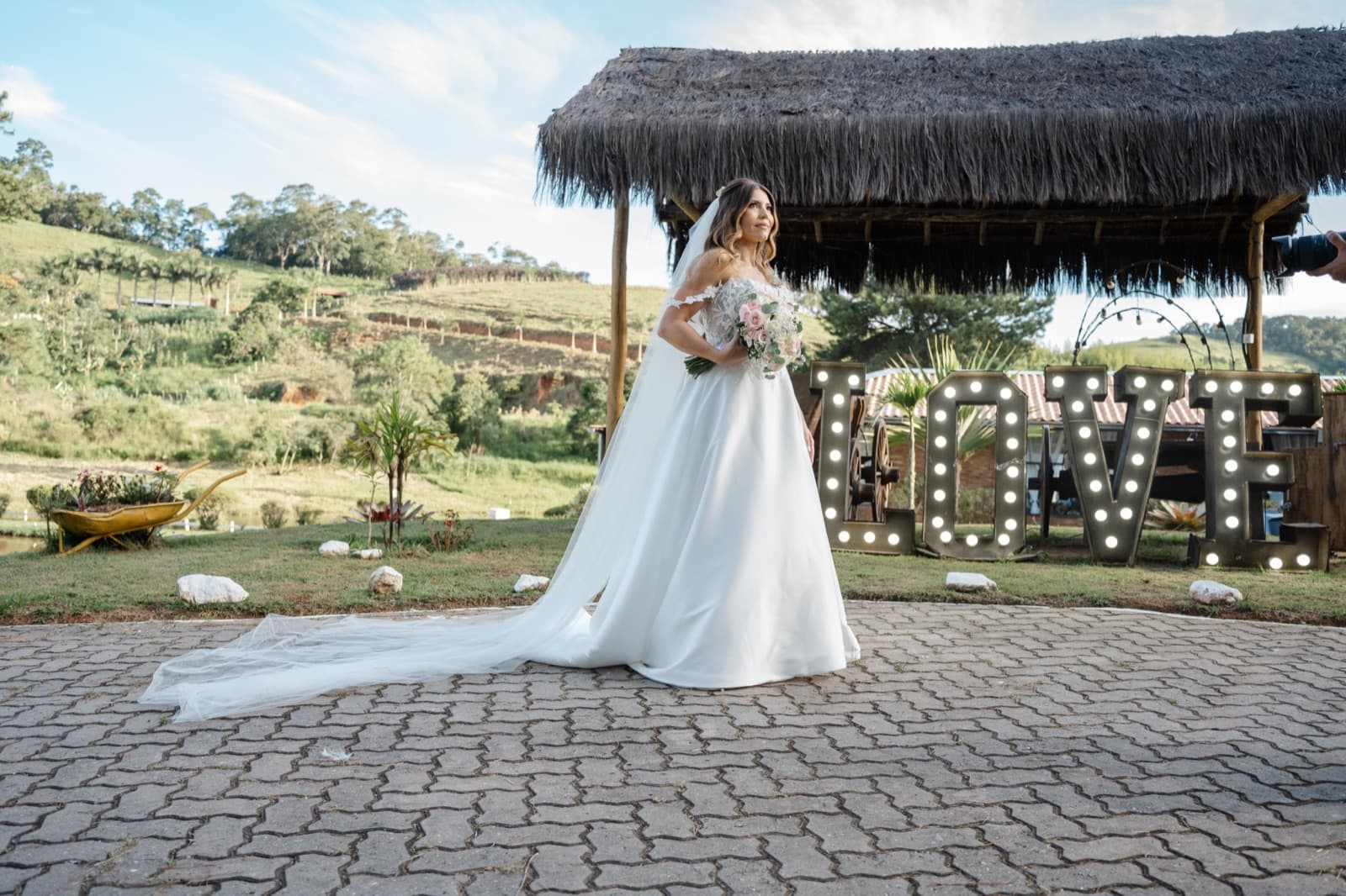 Noiva com o buquê em frente ao letreiro LOVE